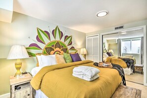 Una habitación de hotel con cama, mesita de noche, espejo y armario.