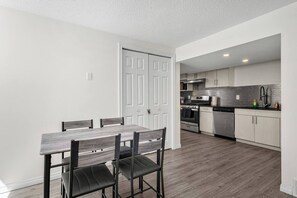 A modern kitchen with white cabinets, a stainless steel range, and a black countertop. - 3 Bed | Min to UofC & Hospital (Calgary)