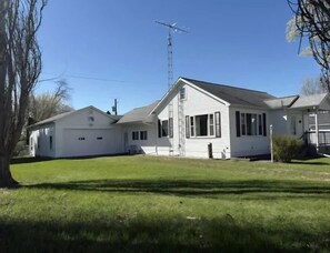 A two-story white house with a large front yard, a garage, and a tall antenna. - Caseville Cherry on Top- 2 mins from the beach!! (Caseville)