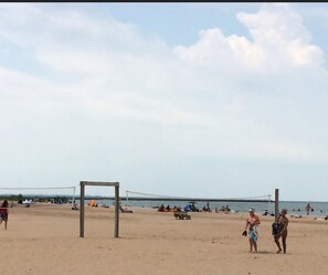 A beach volleyball court with a net, tents, and people in the background. - Caseville Cherry on Top- 2 mins from the beach!! (Caseville)