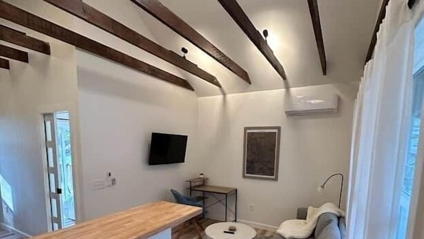 A modern living space with a kitchen area, a dining table, and a sofa.