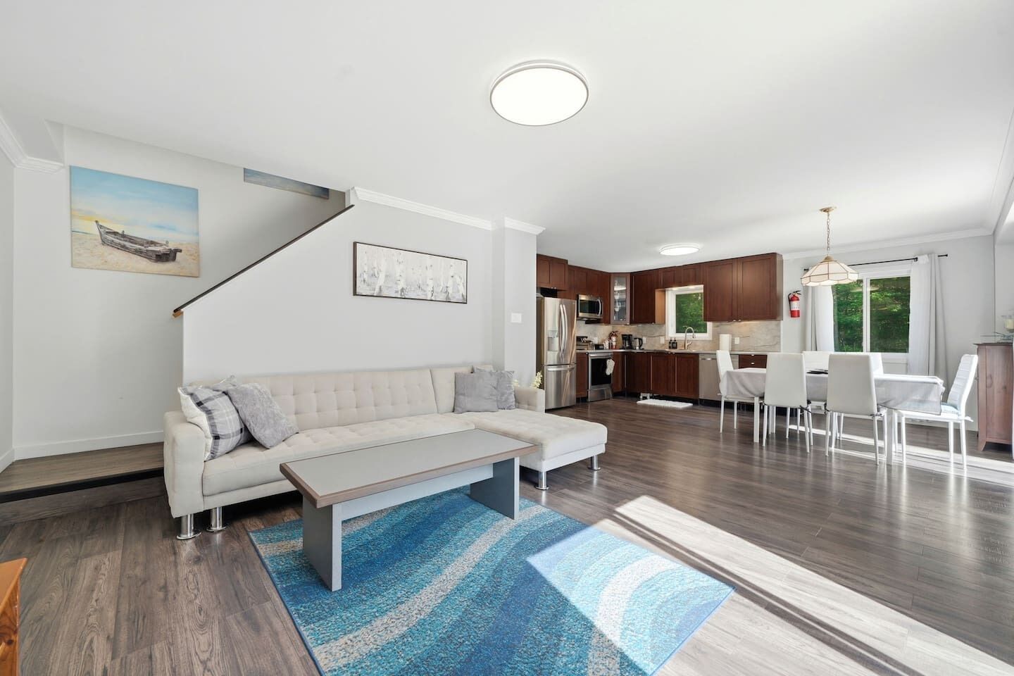 A modern living room with a sofa, coffee table, and a view into the kitchen.