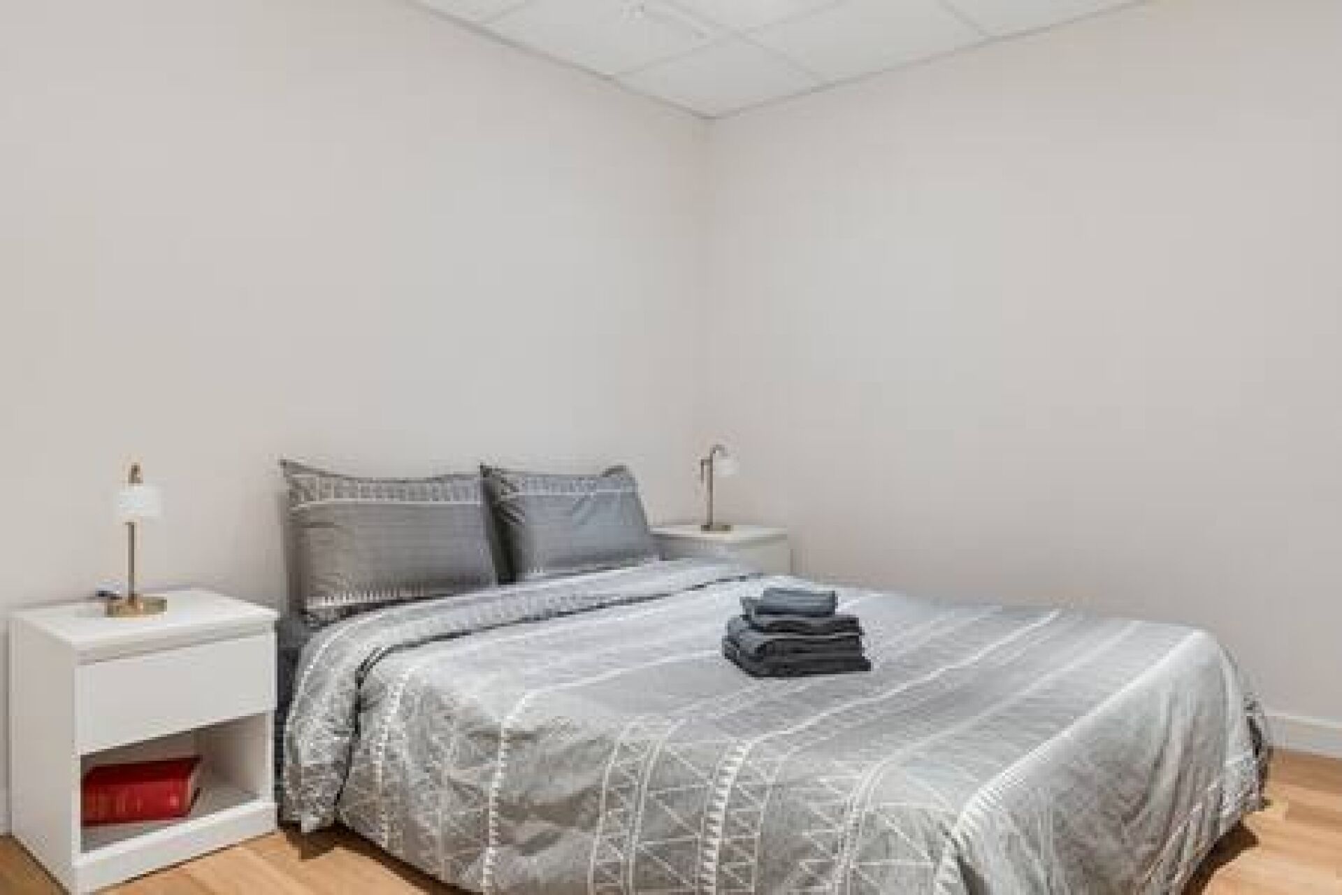 Une chambre à coucher avec un lit, deux tables de chevet et une petite table d’appoint.