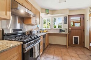 A kitchen with a stove, oven, microwave, and wooden cabinets.