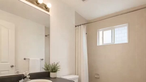 Een badkamer met een wastafel, toilet en bad.