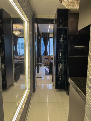 Eine moderne Küche mit Kühlschrank, einer Kaffeemaschine und einem Essbereich mit Tisch und Stühlen.