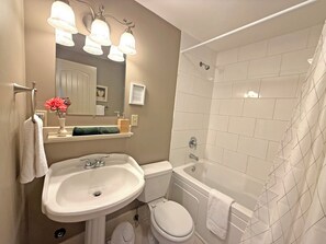 A bathroom with a sink, toilet, bathtub, and a shower.
