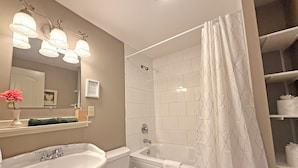 A bathroom with a sink, toilet, bathtub, and shower curtain. - Oceanfront Suite with Relaxing Tub & Private Bath - Rm 5 (Gabriola)