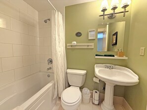 A bathroom with a bathtub, toilet, sink, and a mirror. - Forestview Suite with Relaxing Tub & Private Bath - Rm 4 (Gabriola)
