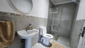 A bathroom with a sink, toilet, and shower.
