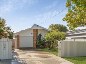 Ein Wohnhaus mit Garage, Auffahrt und umzäunter Garten.