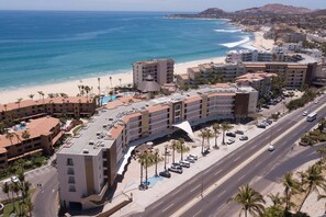 A coastal hotel with multiple buildings, a beachfront, and a road with parked cars. - Estudio a 5 min de la playa en San José del Cabo (San José del Cabo)