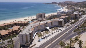 Ein Küstenhotel mit mehreren Gebäuden, einem Strand und einer Straße.