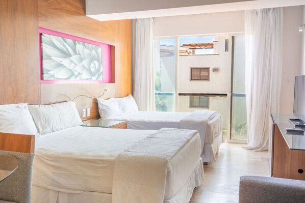 Une chambre d’hôtel avec deux lits, une télévision et un balcon avec vue.