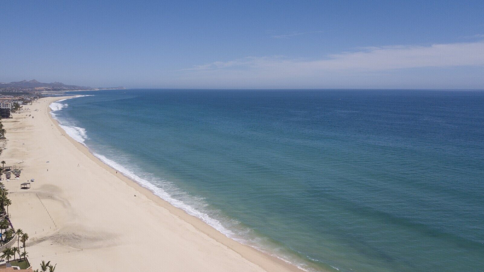 Una playa con vista despejada al océano y una orilla arenosa.