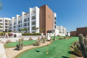 Ein Hotel mit mehreren Etagen, Außenbereich und Kakteen im Innenhof.