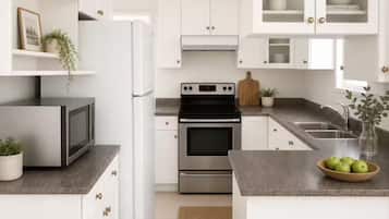 A modern kitchen with white cabinets, stainless steel appliances, and a granite countertop.