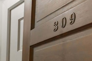 Puerta de madera con el número '309' que indica un número de habitación.