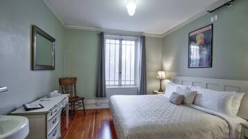 Une chambre à coucher avec un lit, une chaise, un bureau et une fenêtre.