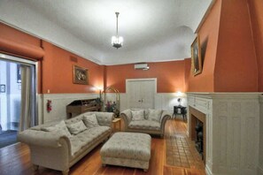 A living room with two sofas, a fireplace, and a ceiling light fixture.