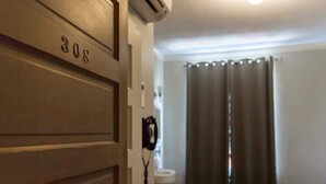 A hotel room with a door labeled '308,' a telephone, and a window with curtains. - The Peak at Centralia Square | Room 308 (Centralia)