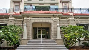 A building with a central entrance, a red-tiled roof, and a sign reading 'CENTRALIA SQUARE'. - The Peak at Centralia Square | Room 308 (Centralia)