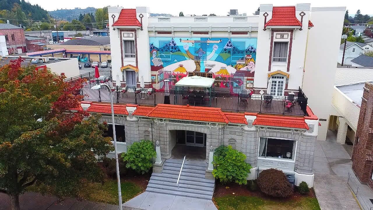 Een gebouw met een muurschildering, een balkon en een rood dak.