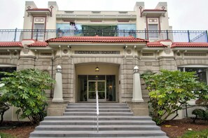 A building with a sign reading 'CENTRALIA SQUARE' at the entrance, featuring a grand staircase, columns, and a balcony with railings.