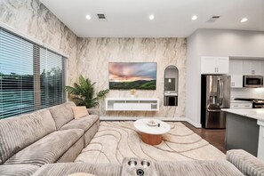 Ein modernes Wohnzimmer mit Sofa, Couchtisch und einem Gemälde an der Wand.