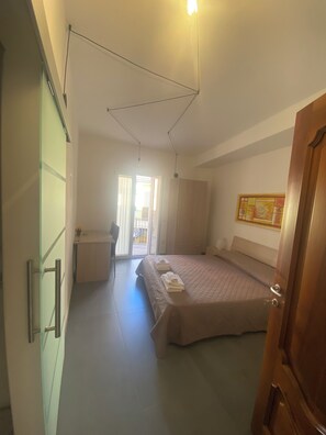 Una camera da letto con un letto, una scrivania e una porta.