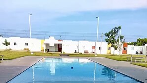 En rektangulär swimmingpool med ett kaklat botten, omgiven av ett trädäck.