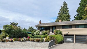 A two-story house with a garage, a front porch, and a well-maintained garden. - Exceptional 3 bedroom/3 bath +Office -  Shorewood on the Sound! (Burien)