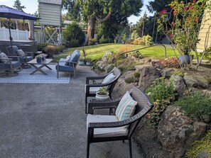 A patio with outdoor furniture, a hot tub, and a garden with rocks and plants. - Exceptional 3 bedroom/3 bath +Office -  Shorewood on the Sound! (Burien)