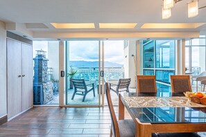 A modern interior with a glass door leading to a balcony with a city view. - The Cebu Skyline Penthouse Romantic Getaway with Pool, King size Bed, 2 BR (Cebu City)