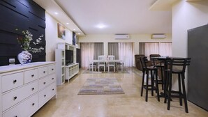 Une cuisine moderne avec un coin repas, des meubles blancs et un vase décoratif.