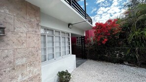 Ein modernes Gebäude mit weißer Fassade, einer großen Garagentür und einer Schotterauffahrt.