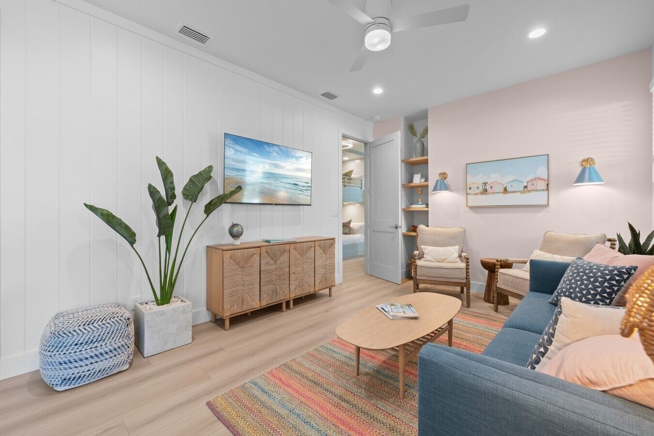 A modern living room with a sofa, armchair, coffee table, and a bookshelf.