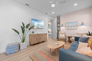 Una sala de estar moderna con sofá, sillón, mesa de centro y estantería.