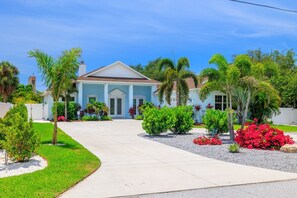 A residential house with a front lawn, a driveway, and various plants and shrubs. - Luxury Estate w/ Amazing Outdoor Space, Slps 24 (Bradenton)