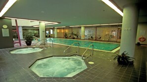 An indoor swimming pool with two hot tubs, a tiled floor, and a ceiling with recessed lighting. - Banff National Park Escape Near Downtown & Adventure (Vancouver)