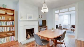A dining area with a fireplace, bookshelves, and a chandelier.