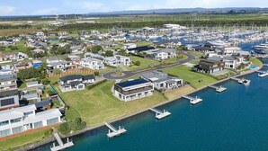 A marina with boats, modern houses, and a clear sky. - Waterfront Base with Private Pontoon and Kayaks (One Tree Point)