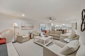 A modern living room with a sofa set, coffee table, and floor lamp. - Weldons' Kyle Field Cottage (College Station)