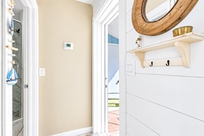A room with a beige wall, a white door, and a wooden-framed mirror. - Cozy Lido Studio by Beach & St Armand's (Sarasota)