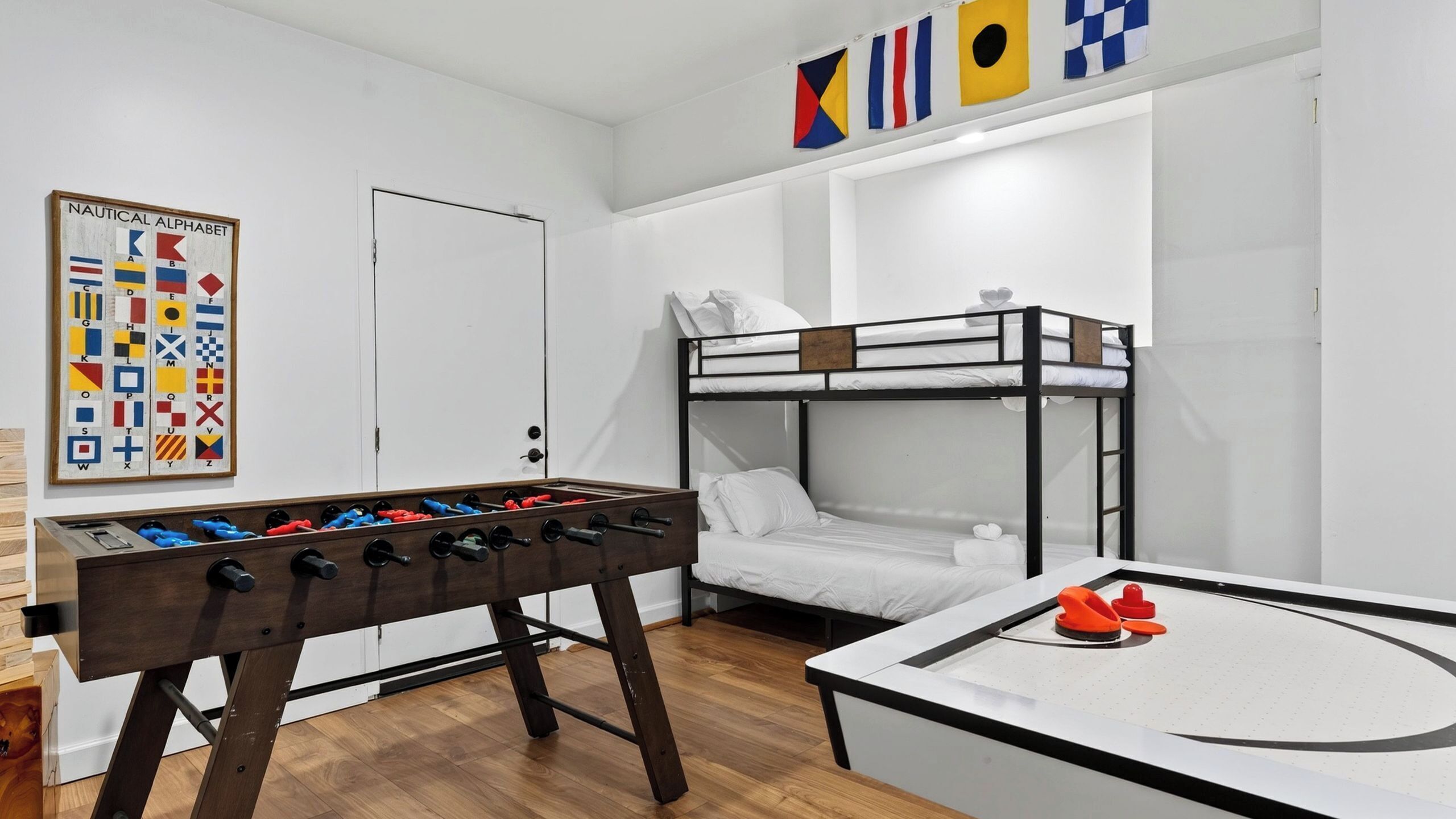 Una cama litera, una mesa de futbolín y otra mesa de futbolín con portería.