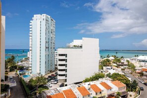 Ein Hochhaus-Hotel mit mehreren Etagen, einem Pool und Blick auf den Ozean.
