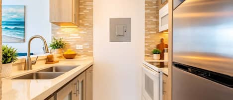 Modern kitchen with sleek countertops, stainless steel appliances, and stylish backsplash—fully equipped and ready for your stay. Perfect blend of functionality and elegance.