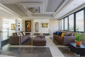 Elegant and inviting lobby featuring modern decor, cozy seating, and artistic touches—offering guests a welcoming space to relax before exploring Isla Verde. - 1BR Beachfront Apt with Queen Bed Isla Verde (aven ida)