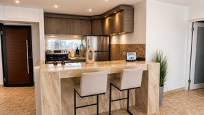 A modern kitchen with a marble countertop, stainless steel appliances, and a sign that reads 'COFFEE TIME'. - Beachfront Stella Maris Apt on Condado Ave (SanJuan)