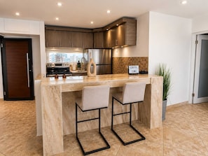A modern kitchen with a marble countertop, stainless steel appliances, and a sign that reads 'COFFEE TIME'. - Beachfront Stella Maris Apt on Condado Ave (SanJuan)